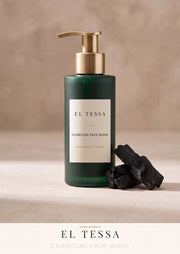 EL TESSA deep cleansing charcoal face wash in a green pump bottle next to pieces of activated charcoal